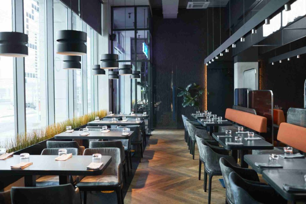 Rows of restaurant tables and chairs in gray room